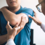 Physical therapists are checking patients elbows at the clinic office room.