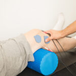 Physiotherapist's Hand Positioning Electrodes On Patient's Knee